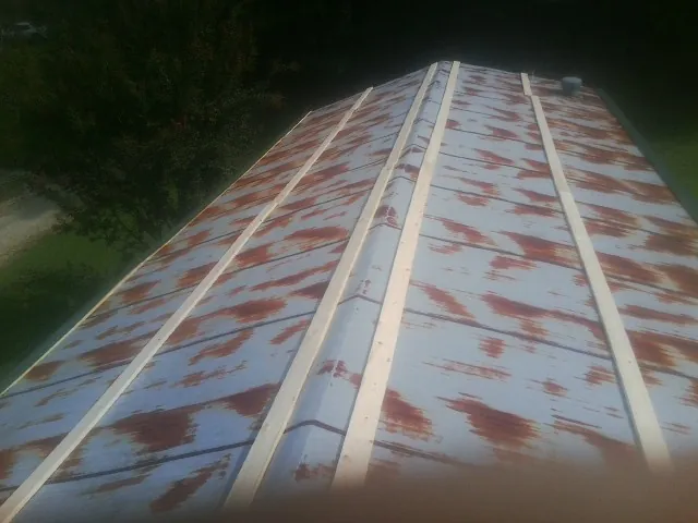Rusted metal roof panels with new wood purlins before replacement — Storm Damage Roof Repair in Erath by Roofing Brothers
