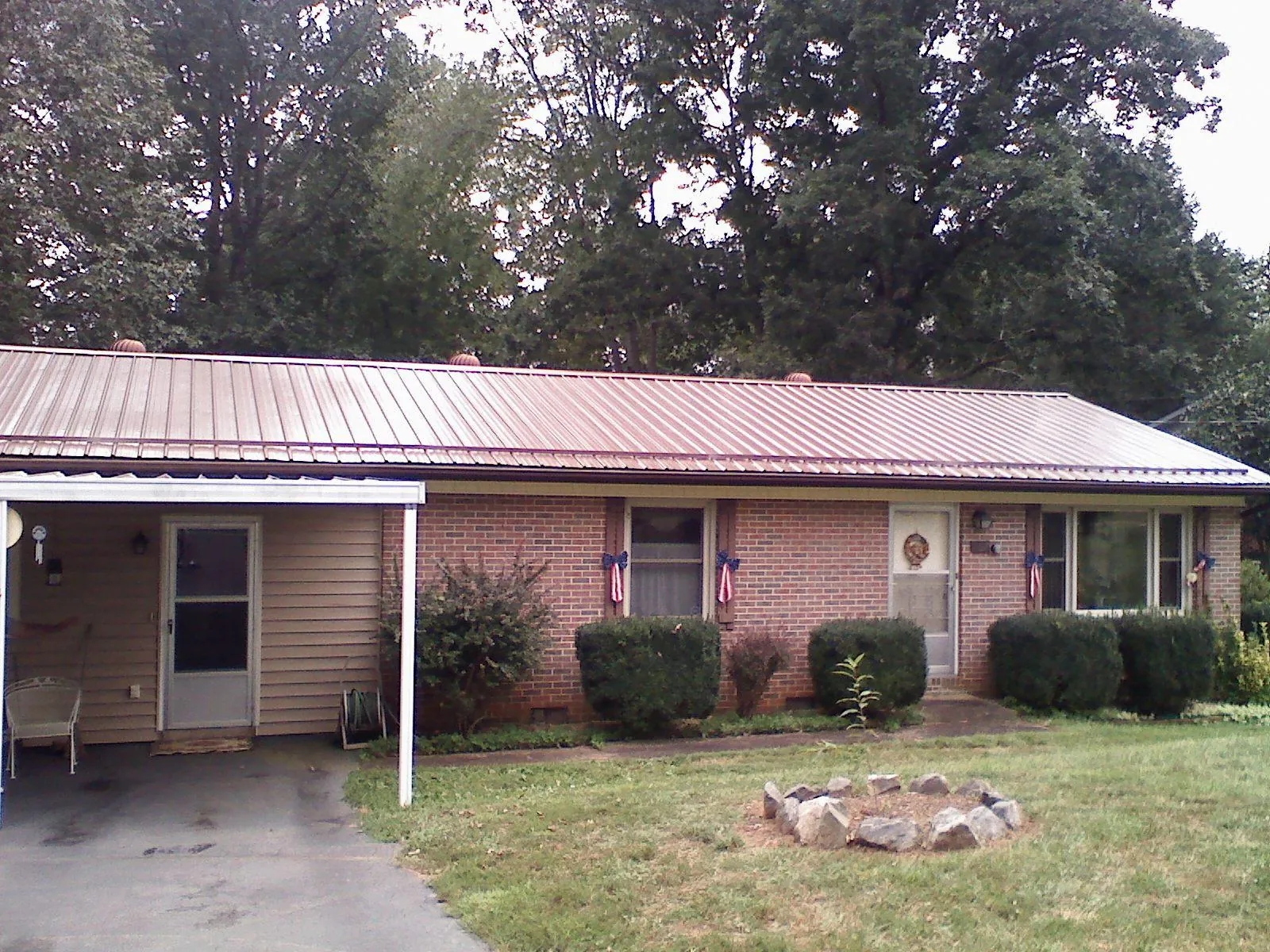 Bronze metal roof and carport on a brick ranch home — Roof Repair work by our crew in Erath