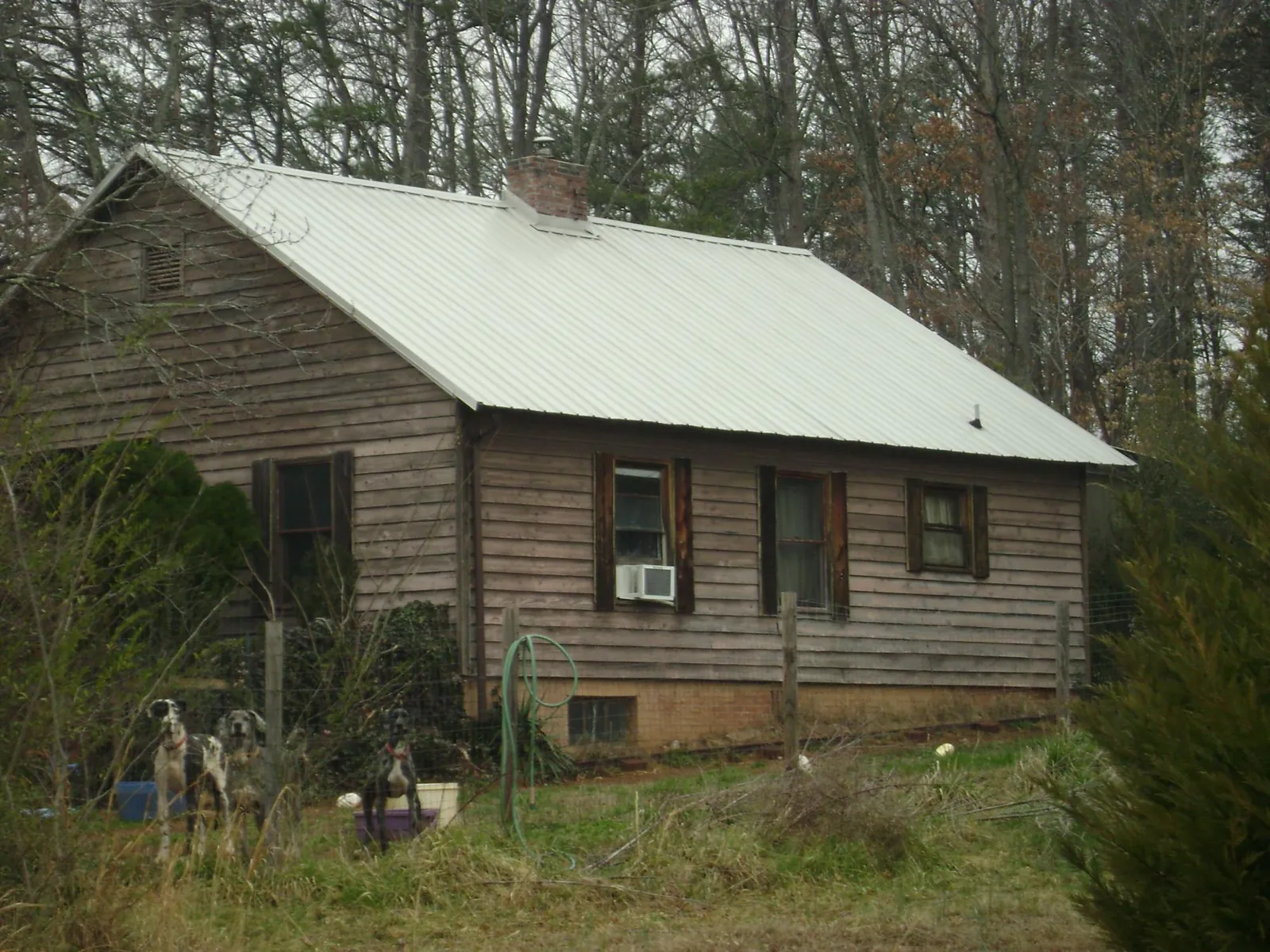 White metal roof on an old wood sided farmhouse, from a Metal Roof Installation job in Erath